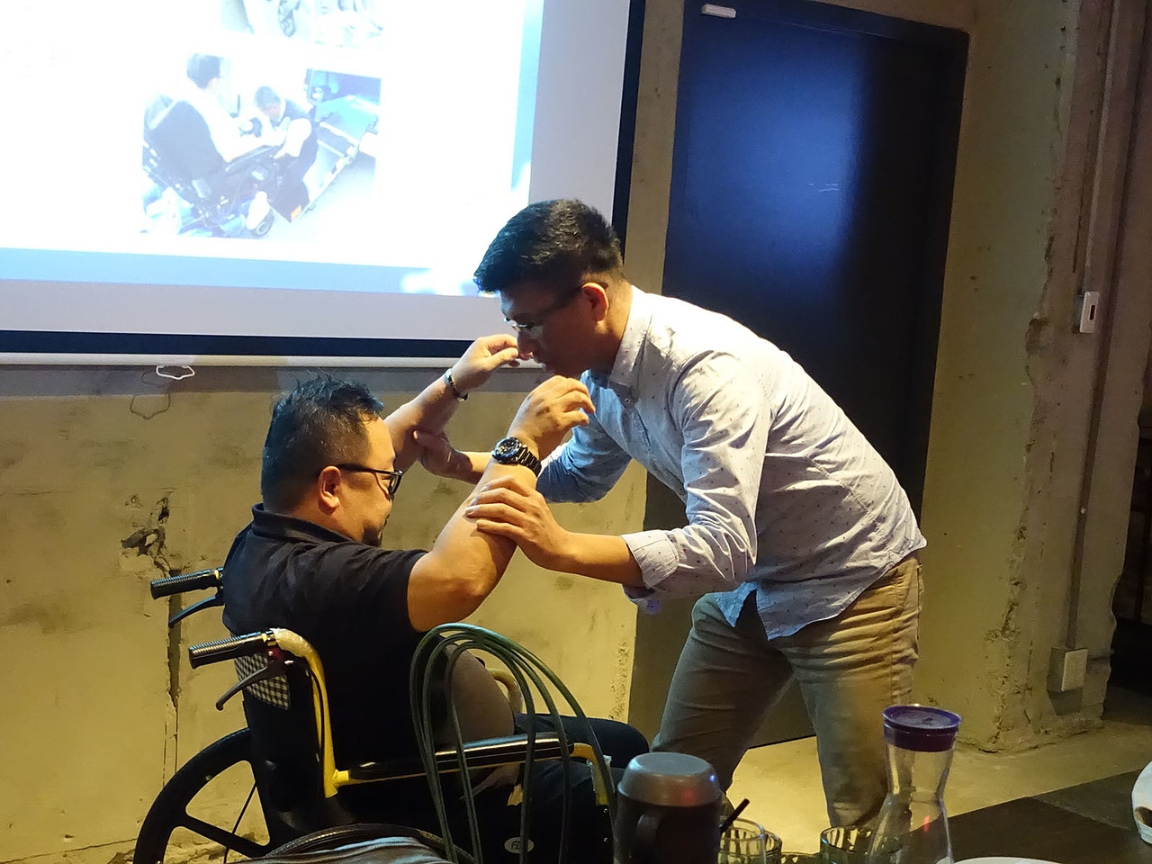 學員互相擁抱模擬攙扶行動不便者上下輪椅
